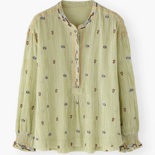 Green patterned blouse on a white background